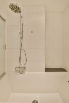 a white bathtub in a bathroom with a shower head mounted on the wall next to it is a glass door