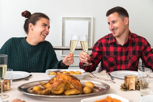 Young caucasian couple toasting with champagne in Christmas family reunion dinner. In love. Holiday concept. Romance concept.