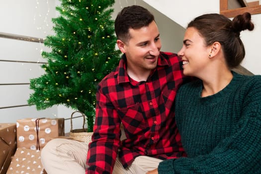 Smiling young caucasian couple at home celebrate Christmas together. Holiday concept.