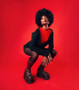 Black woman, makeup and afro, hair and fashion in portrait with shine isolated on red background. Hairstyle, haircare and texture with growth, stylish clothes and confident African model in a studio.