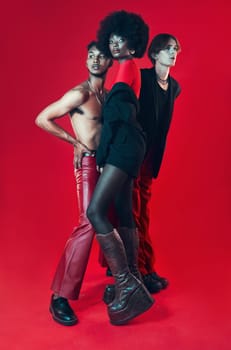 Fashion, group and portrait with diversity of gay people with creative black woman, man and model on red background. Lgbt, friends and beauty for edgy, gen z or unique aesthetic makeup in studio.