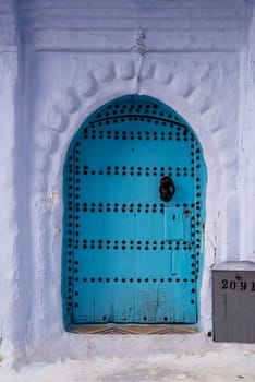 Vibrant blue colored wooden door in downtown Chefchaouen, Morocco