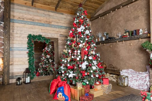 Christmas, New Year interior with red brick wall background, decorated fir tree with garlands and balls, dark drawer and deer figure