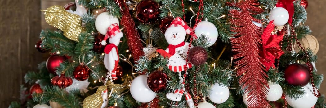 Christmas, New Year interior with red brick wall background, decorated fir tree with garlands and balls, dark drawer and deer figure