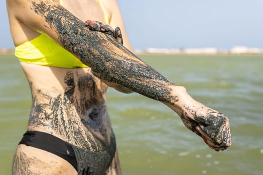 girl in healing mud. The girl's feet are immersed in a lake with healing mud. Treatment in a mud bath. High quality photo