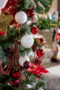 Christmas, New Year interior with red brick wall background, decorated fir tree with garlands and balls, dark drawer and deer figure