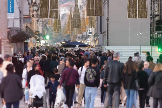 14 november 2023, Lisbon, Portugal - crowd of people walking down a street Rua Agusta near Commercio plaza- telephoto
