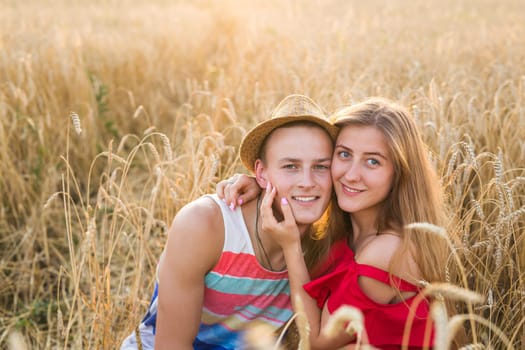 Happy outdoor portrait of young stylish couple in summer in field