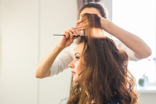 Reflection of hairdresser doing hair style for woman in hairdresser's. Concept of fashion and beauty