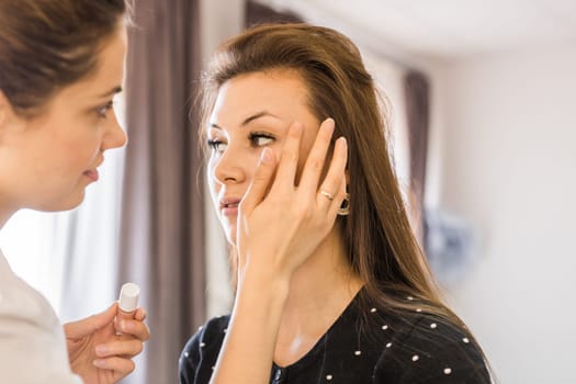 makeup artist applying make up on model.