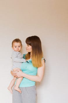 Happy mother with adorable baby boy in the bedroom