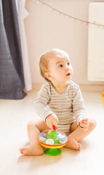 Little cute baby boy plays in his room