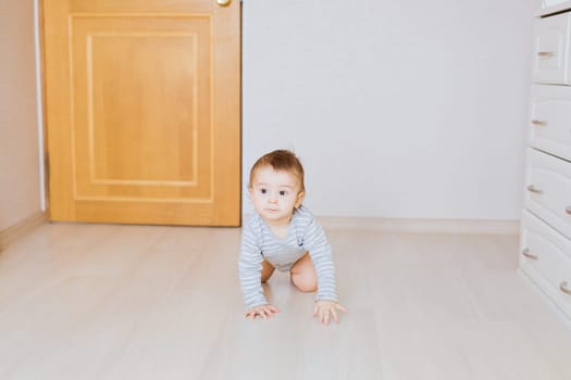 Portrait of a crawling baby boy in the bedroom