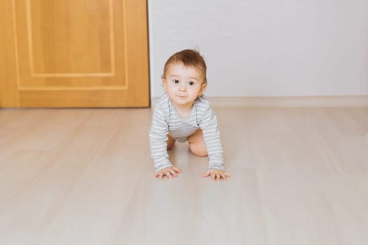 Portrait of a crawling baby boy in the bedroom