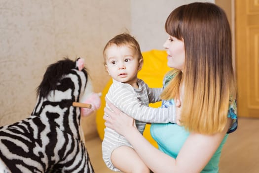 Happy mother with adorable baby boy in the bedroom