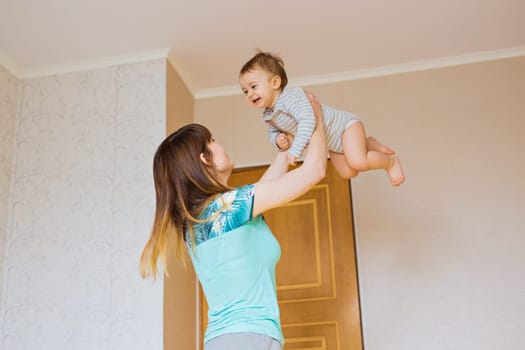 Happy mother with adorable baby boy in the bedroom