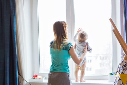 Happy mother with adorable baby boy in the bedroom