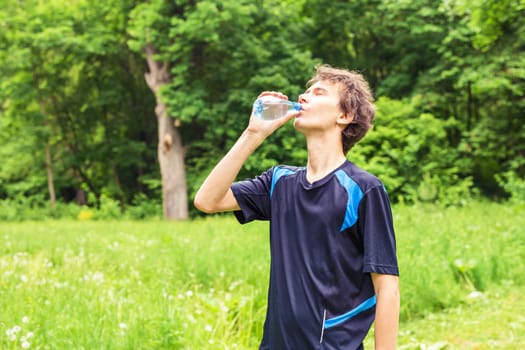 Man having break from sport training and drinks water.