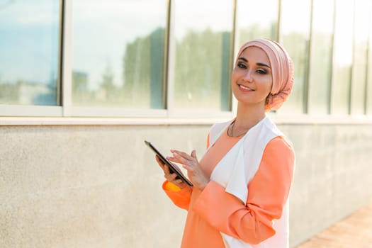 Portrait of an Arab businesswoman in hijab holding a tablet