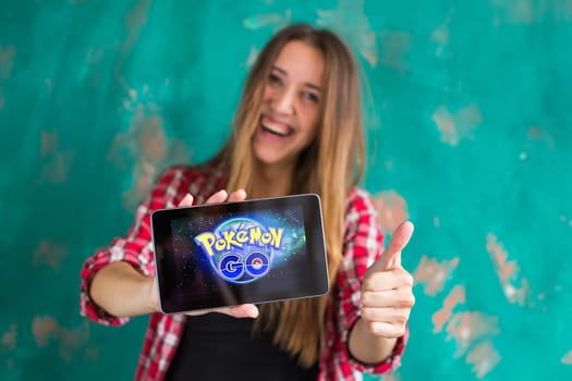 Woman show the tablet with Pokemon Go logo