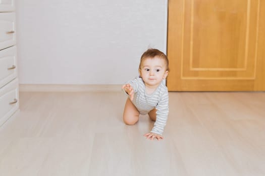 Happy crawling baby boy in his bedroom