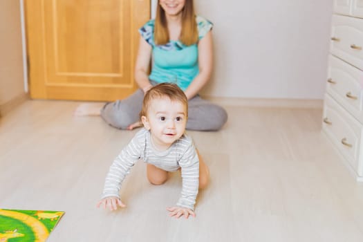 Happy crawling baby boy with his mother
