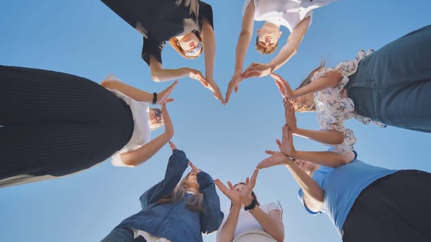 School children make a heart shape from their hands