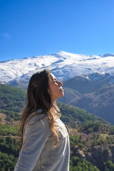 latina woman,long hair,breathing fresh air at the top of the mountain,sierra nevada spain,