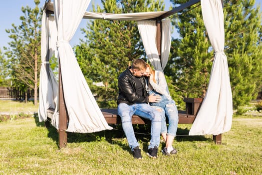 Happy couple awaiting baby, cute pregnant woman with husband enjoying spring weather, love concept.