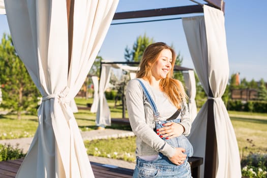 young happy pregnant woman relaxing and enjoying life in autumn nature.