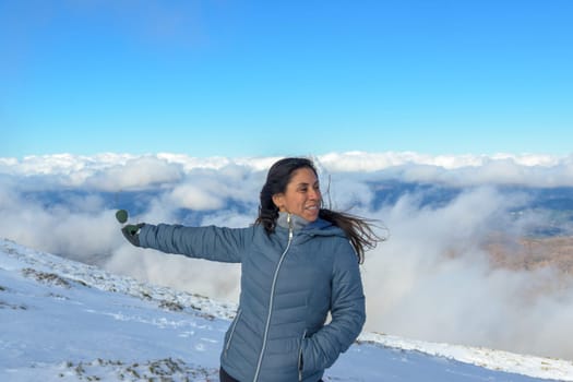 portrait of latina woman in the snow above the clouds