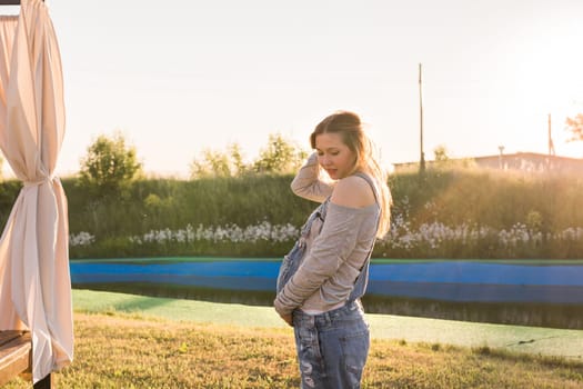 young happy pregnant woman relaxing and enjoying life in autumn nature.