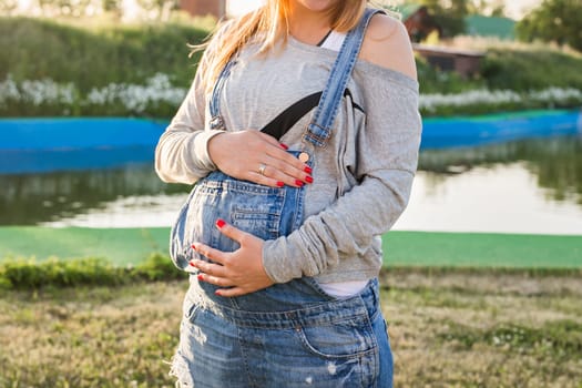 Close up of a cute pregnant belly outdoors