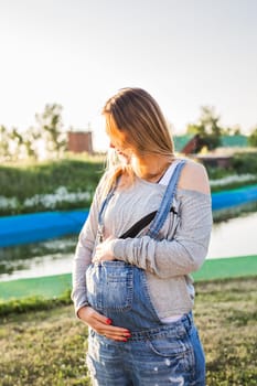 young happy pregnant woman relaxing and enjoying life in autumn nature.