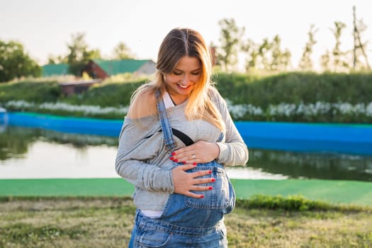 young happy pregnant woman relaxing and enjoying life in autumn nature.