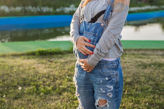 Close up of a cute pregnant belly outdoors