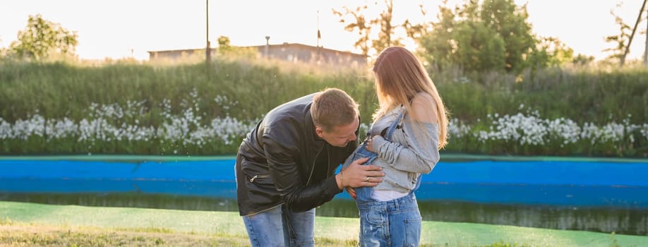 Happy smiling future parents on the walk in autumn park.