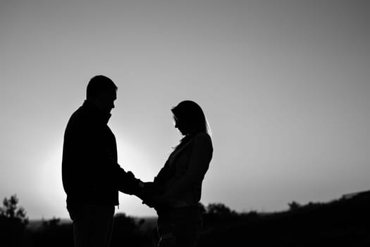 Pregnant couple silhouettes. happy pregnant couple at sunset beach