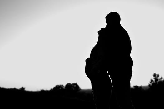 Pregnant couple silhouettes. happy pregnant couple at sunset beach