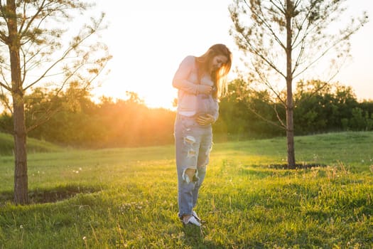 young happy pregnant woman relaxing and enjoying life in autumn nature.