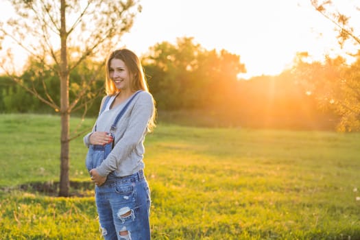 young happy pregnant woman relaxing and enjoying life in autumn nature.