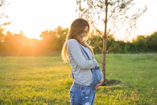 young happy pregnant woman relaxing and enjoying life in autumn nature.