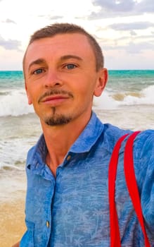 Male tourist Travelling man taking selfie photo on the beach in Playa del Carmen Quintana Roo Mexico.