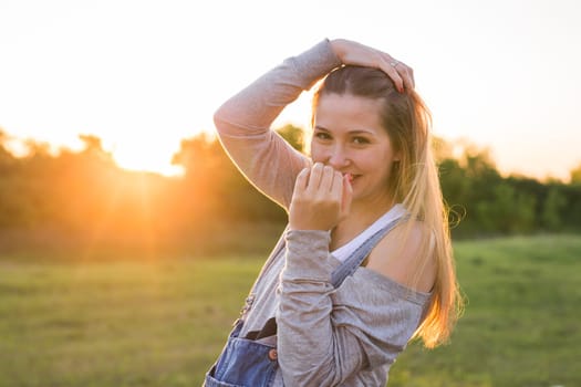 Surprised young woman with hands over her mouth outdoor.