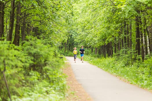 fitness, sport, friendship and lifestyle concept - smiling couple running outdoors