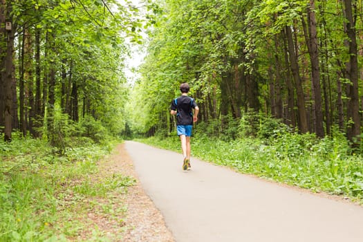 Athletic young man running in the nature. Healthy lifestyle.