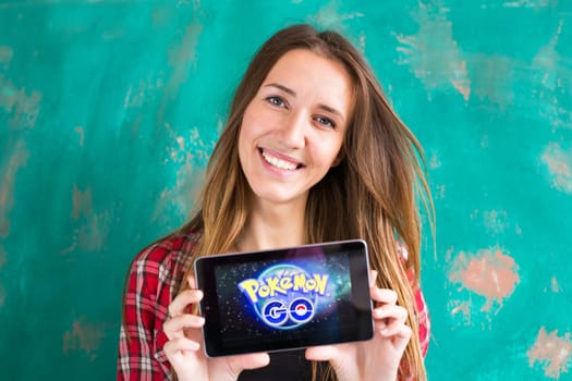 Ufa, Russia. - July 29: Woman show the tablet with Pokemon Go logo