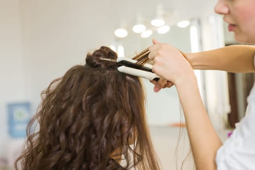 working day inside the beauty salon. Hairdresser makes hair styling