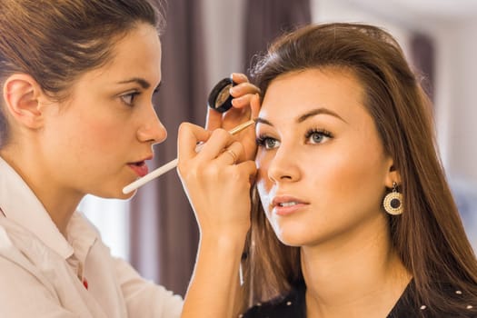 Closeup of a makeup artist applying makeup