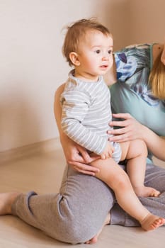 Mother holding sweet baby boy in the room